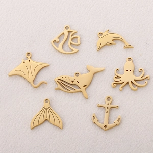Set of 7 golden stainless steel ocean charms including whale tail, dolphin and anchor