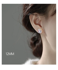 Detailed view of a 12mm iridescent mermaid pearl stud earring worn on a model's ear