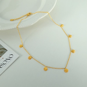 Gold shell pendant necklace with seven small shells on a delicate chain with extension