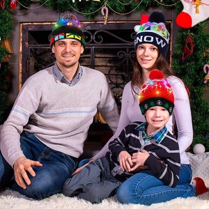 Detailansicht einer Familie mit LED-gestrickten Weihnachtsmützen in gemütlicher Atmosphäre
