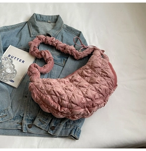 Pink quilted velvet tote bag with ruched strap displayed on a casual denim jacket