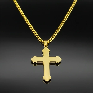 Détail d'un pendentif double croix dorée sur une chaîne cubaine au lustre métallique