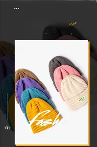 Detailed view of colorful knitted beanies with ribbed texture and woven letter labels