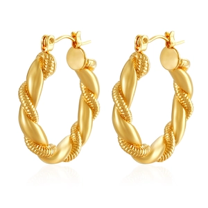 Detailed view of gold twisted hoop earrings with a polished and textured metal finish