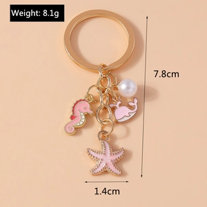 Detail showing golden seahorse, whale and starfish charms with dimension labels