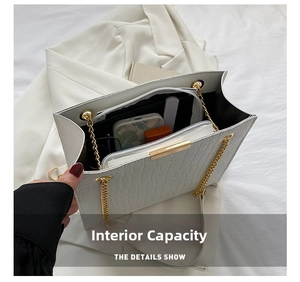 Internal view of white faux crocodile leather bag showing space for phone and makeup