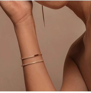Close-up of stacked rose gold s925 silver bracelets with zircon cubes on a female wrist