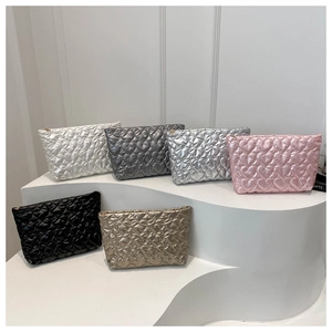 Quilted heart cosmetic bags shown in multiple metallic colors on display steps