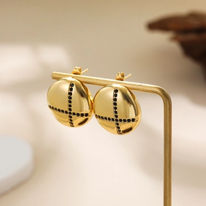 Detailed view of 18K gold disc stud earrings with black zircon cross pattern on a stand