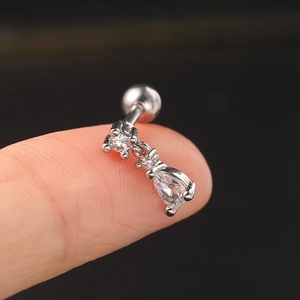Detailed macro view of silver steel helix stud with teardrop zircon on a fingertip