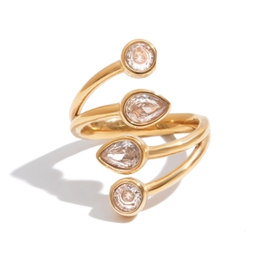 Detail of golden spiral ring featuring two round and two pear-cut zircon stones