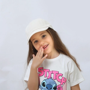Close-up of a white kids baseball cap paired with a cute cartoon character t-shirt