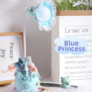 Dettaglio di una lampada da tavolo blu fantasia con una piccola principessa e conchiglie