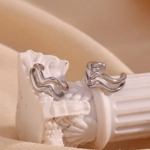Macro shot of silver double-layered wave ear cuff displayed on white decorative pedestal