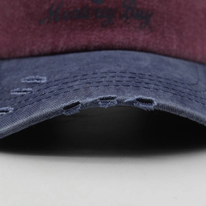 Close-up of distressed cotton baseball cap with Monterey Bay embroidery and navy brim