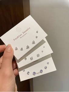 Detail view of fashion jewelry set with silver geometric studs and clear cubic zirconia