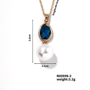 Vue détaillée du collier doré avec gemme bleue à losanges et perle élégante