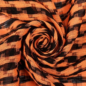 Macro shot of orange and black houndstooth pattern texture on tactical desert scarf