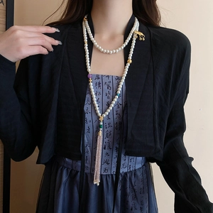 Detail of double-layer lotus pearl body chain with pink crystal tassels and gold accents