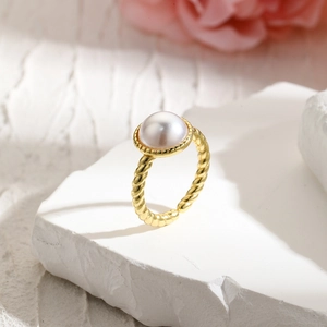 Detailed view of an 18k gold-plated twisted ring featuring a large white baroque pearl