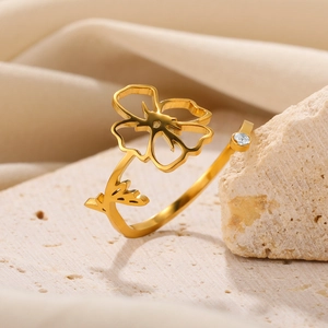 Detailed macro shot of a gold open ring featuring hollow floral design and zircon accent
