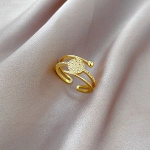 Macro detail of triple-layer gold adjustable ring with pave-set zircon circle centerpiece