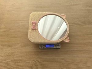 Specchio trucco rosa con strass e orecchie da gatto che pesa 195,9 g sulla bilancia