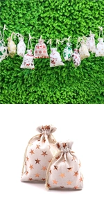 Gros plan de sacs cadeaux de Noël en coton beige et blanc avec motifs étoiles dorées