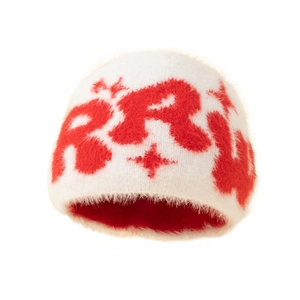 Detail of white plush beanie showing red jacquard letter pattern and soft knit texture