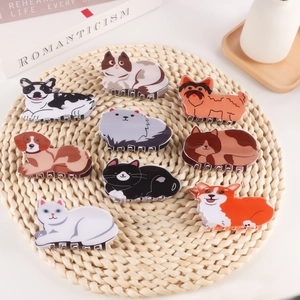 Assorted cute cartoon cat and dog hair claws on a woven mat with cozy lifestyle background