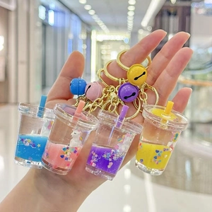 Set of four colorful unicorn milk tea cup keychains with flowing glitter sand liquid