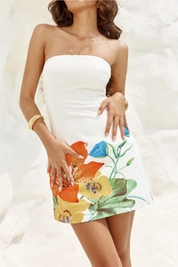 Detail of white tube mini dress with vibrant orange and yellow floral prints