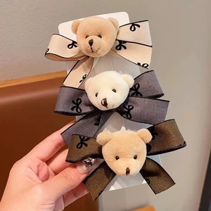 Three plush bear bow hair clips in beige, gray, and brown colors for girls