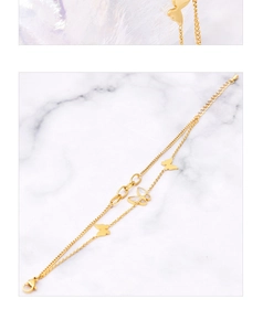 Detail of 18k gold double-layer butterfly bracelet with shell inlay on marble background