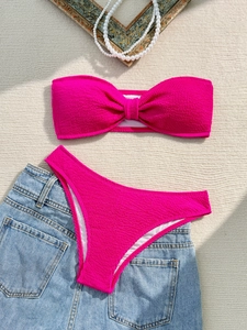 Hot pink bandeau bikini set with bubble texture shown on a beach-themed background