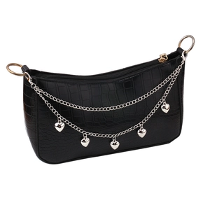Close-up of black crocodile pattern leather texture with silver heart charms and chain