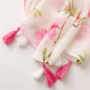 Detail shot of white linen scarf with pink floral pomegranate print and fringe tassels