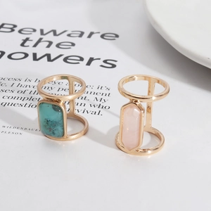 Detail of open gold ring set with rectangular turquoise and hexagonal pink crystal gems