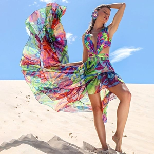Dynamic view of light floral chiffon beach dress with waist cutouts against sand dunes