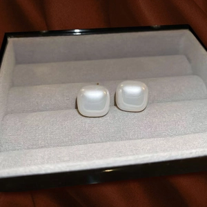 Elegant square pearl stud earrings displayed in a luxury grey velvet jewelry box