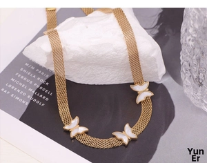 Detail of gold butterfly necklace with mother of pearl inlays on a mesh chain