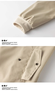 Detail von Rippbündchen und Metalldruckknopftaschen an einer beigen Herrenjacke