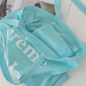 Detailansicht der hellblauen Canvas-Tragetasche mit weißem crème Buchstabendruck