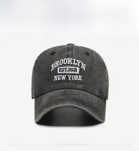 Detail of embroidered Brooklyn lettering on washed dark grey cotton baseball cap