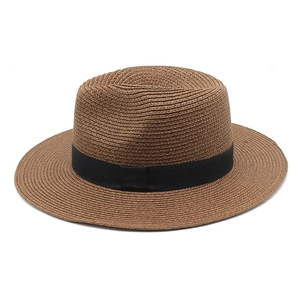 Close-up of tightly woven brown straw hat with elegant black satin ribbon detail