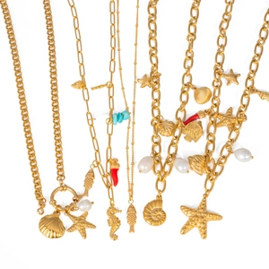 Detail of gold ocean necklaces featuring sea shell, starfish and pearl charms