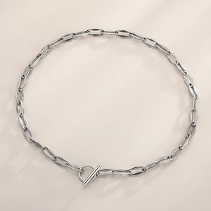 Close-up of silver steel necklace featuring geometric rhombus links and OT toggle clasp