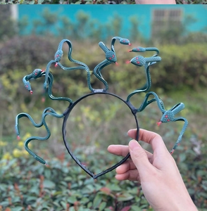 Close-up of Medusa snake headband showing detailed green scales and red eye accents