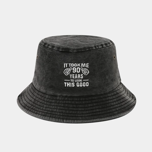 Detail of grey washed cotton bucket hat with white 90th birthday embroidery and eyelet