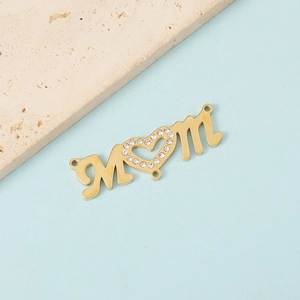 Macro detail of golden MOM pendant with rhinestone heart and triple connection rings